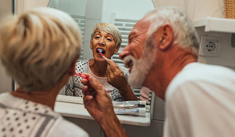 Anciano cepillando los dientes de su esposa