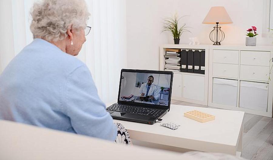 Imagen de un adulto mayor hablando con el médico en la pantalla de la computadora