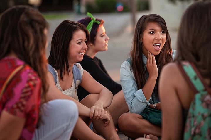 Grupo de adolescentes sentados al aire libre.