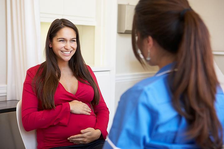 Mujer embarazada hablando con un profesional de la salud