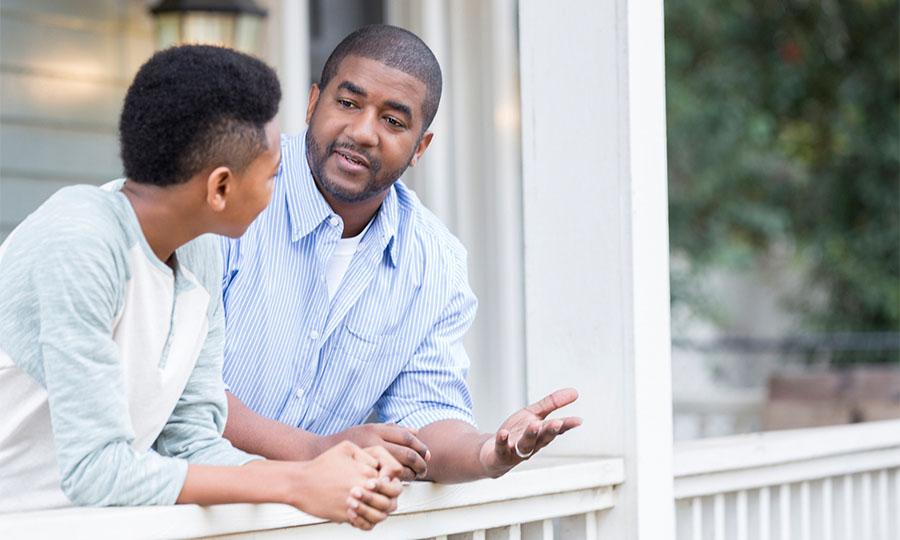 Foto de un padre hablando con su hijo en el portico