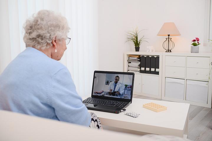 Imagen de un adulto mayor hablando con el médico en la pantalla de la computadora
