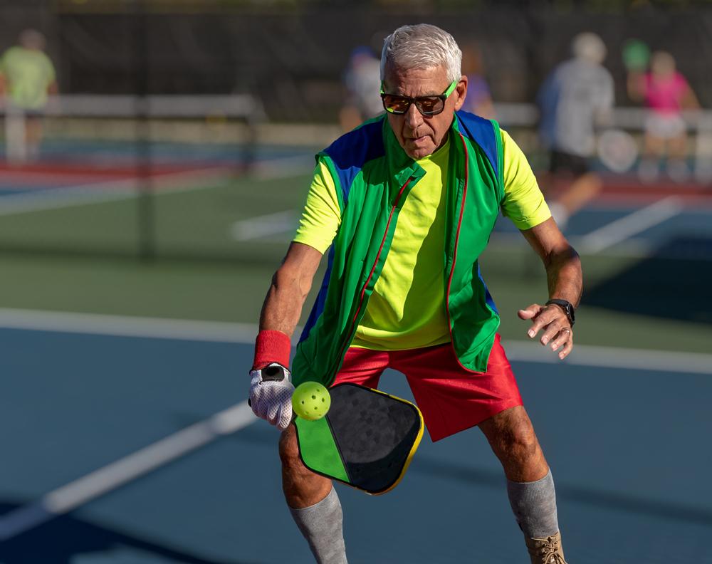 Foto de un hombre mayor jugando pickleball.