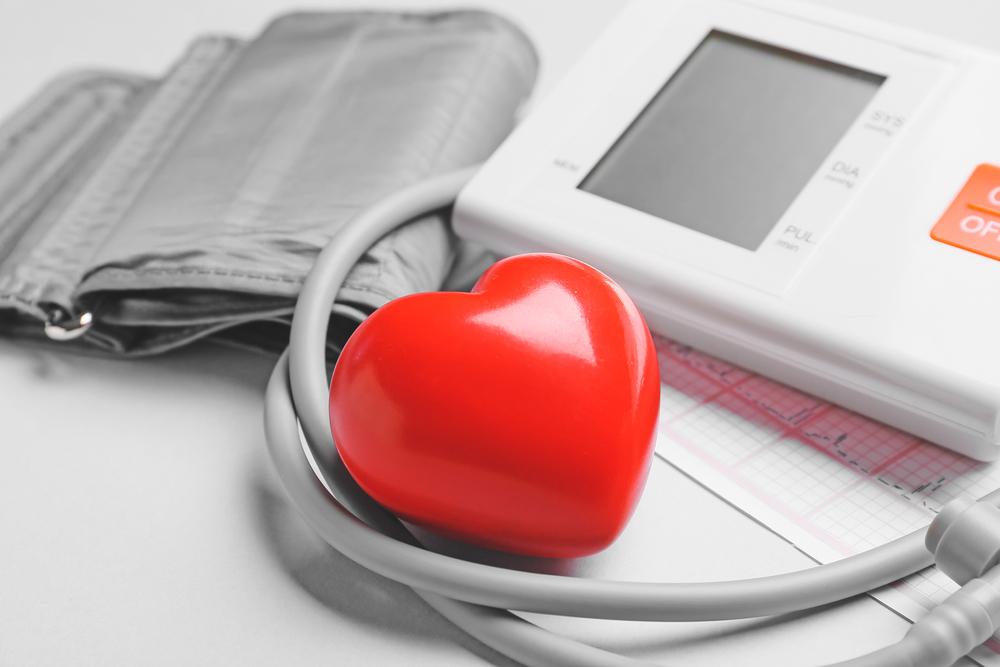 Foto de monitor de presión arterial y corazón rojo.