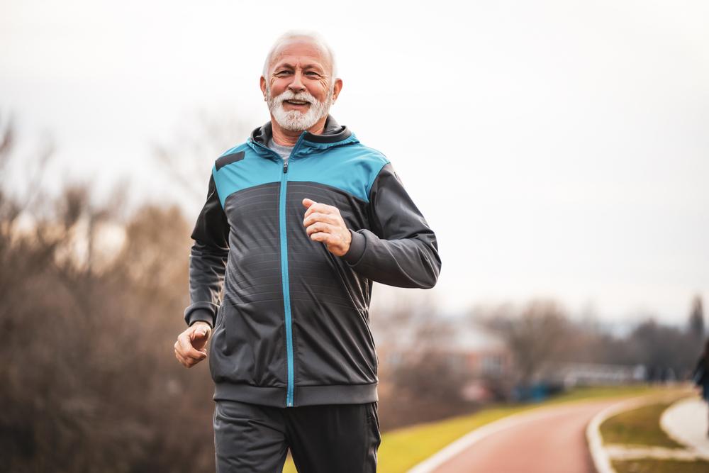 Imagen de un hombre mayor corriendo al aire libre.
