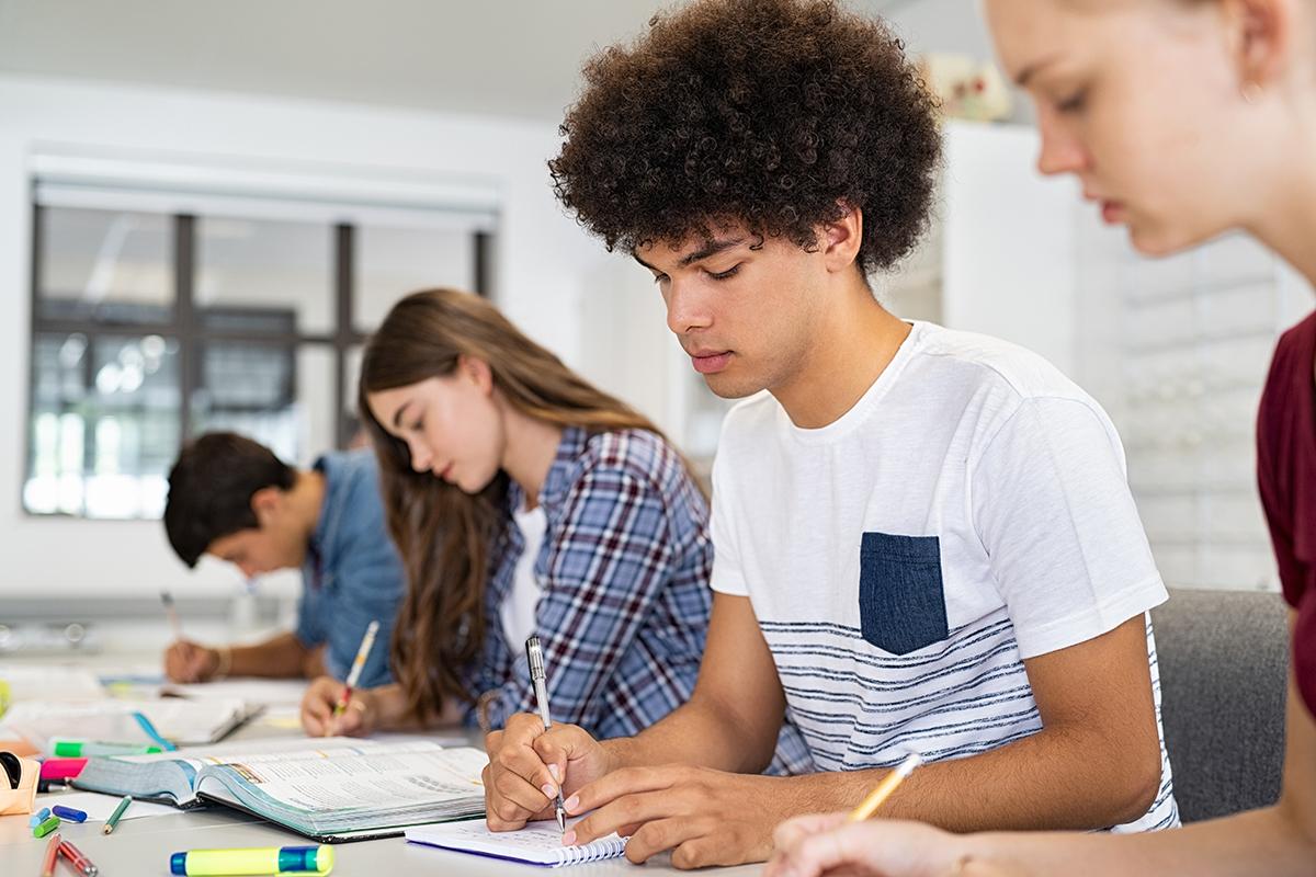 Imagen de estudiantes de secundaria realizando trabajos escolares en clase.