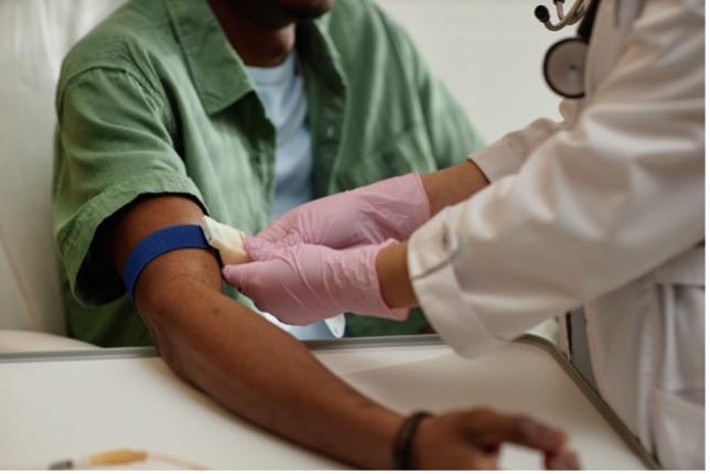 Imagen de un proveedor de atención médica preparando el brazo de un paciente para extraerle sangre.