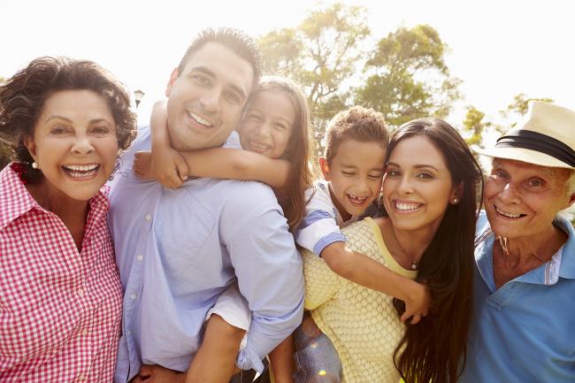 Retrato de una familia multigeneracional sonriendo juntos en un parque