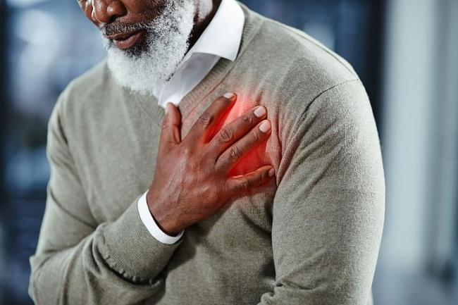 Hombre con la mano sobre el corazón sintiendo dolor