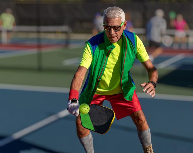 Foto de un hombre mayor jugando pickleball.