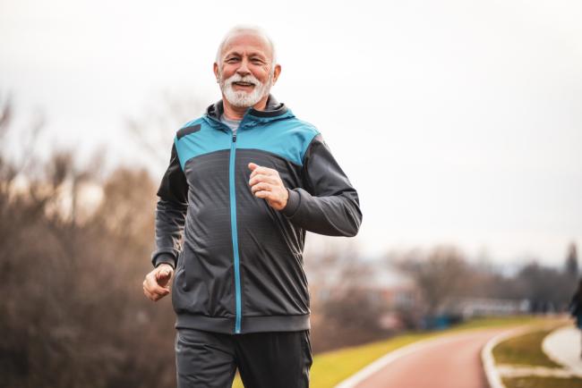 Imagen de un hombre mayor corriendo al aire libre.