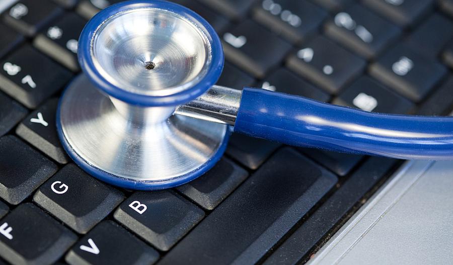 Estetoscopio anglonizado azul en el teclado en un fondo azul