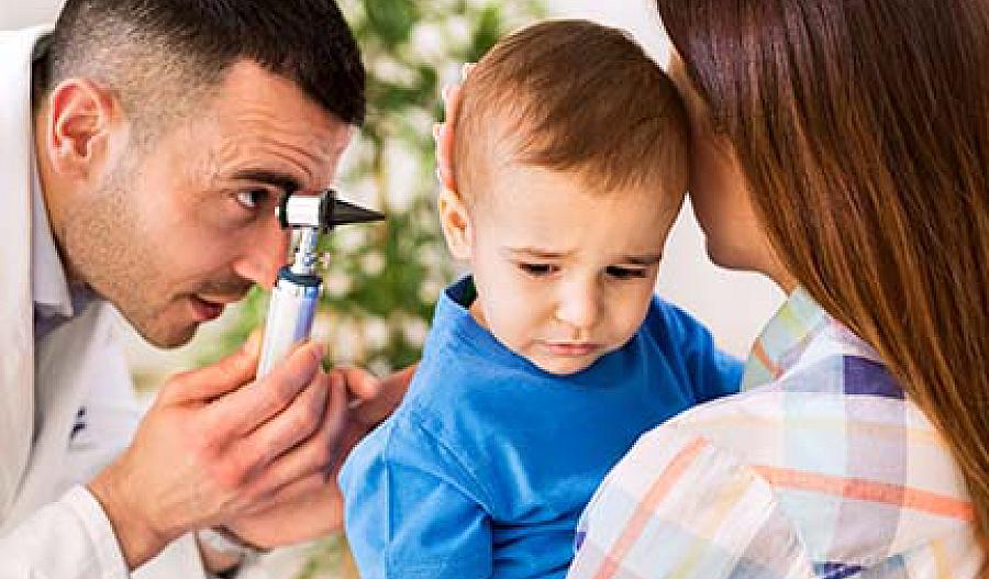 Médico examinando el oído de un niño.