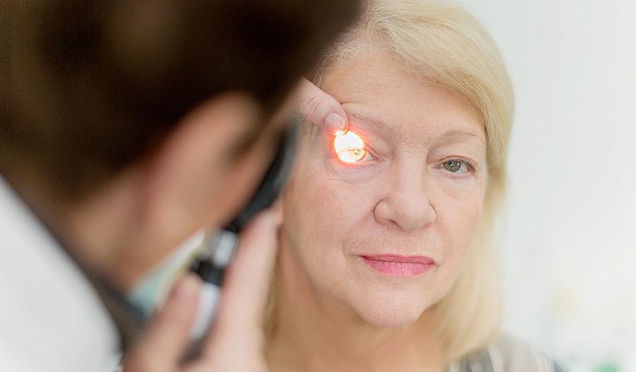Foto de un oftalmólogo que le realiza un examen ocular a una mujer mayor