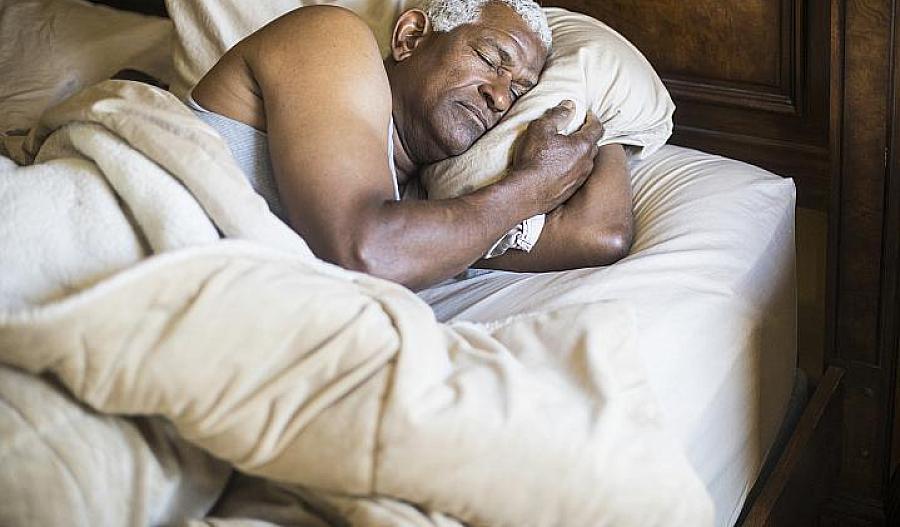 Foto de un hombre afroamericano adulto dormido en la cama