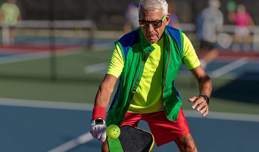 Foto de un hombre mayor jugando pickleball.