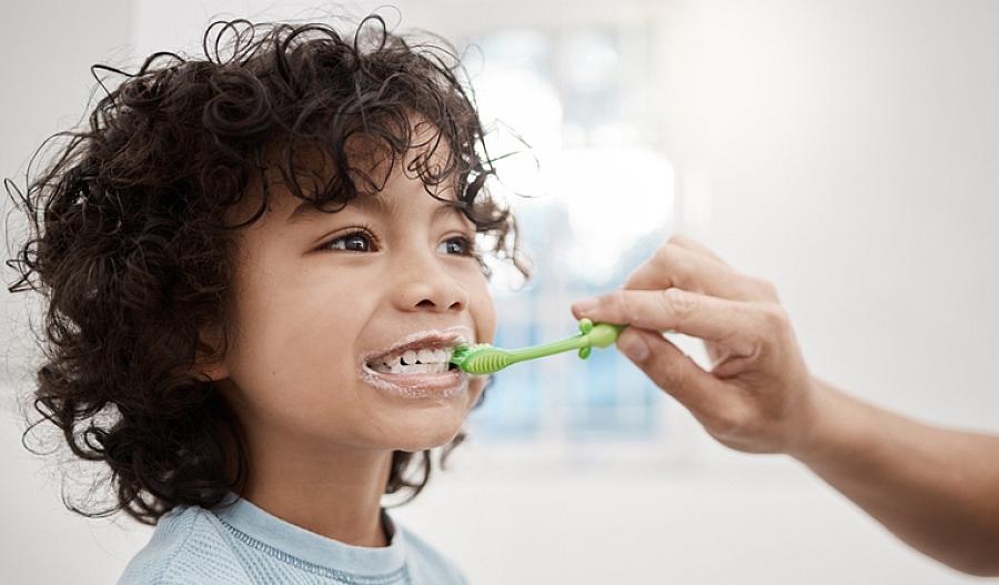 un padre cepillando los dientes de un niño
