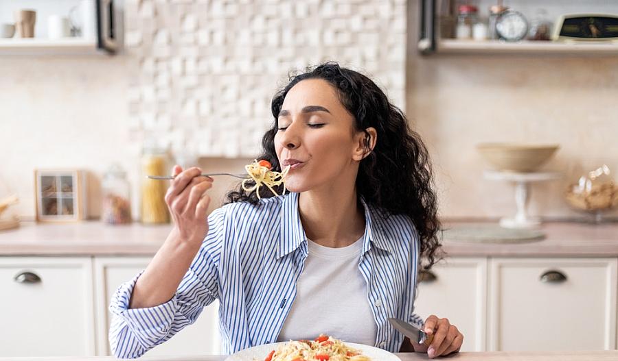 Una imagen de una mujer comiendo espaguetis.