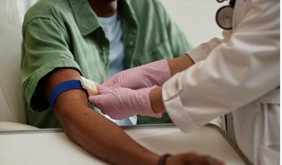 Imagen de un proveedor de atención médica preparando el brazo de un paciente para extraerle sangre.