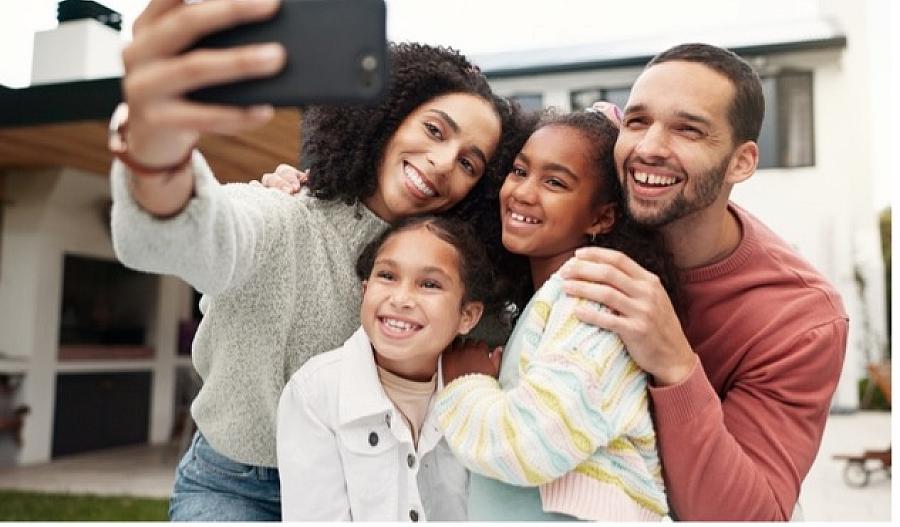 Una imagen de una familia sonriente tomando un selfie.